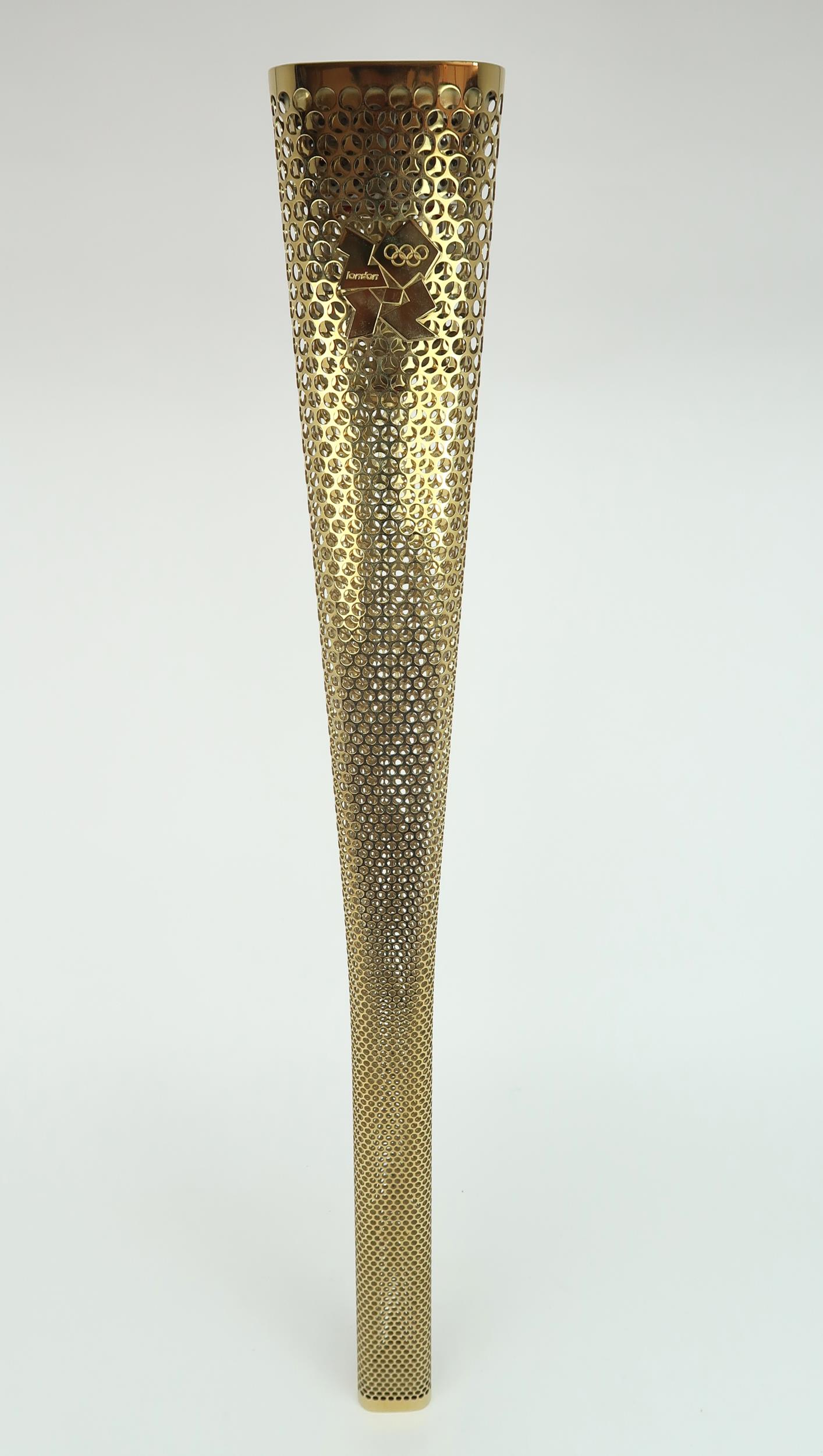 A LONDON 2012 OLYMPIC BEARER'S TORCH Of tapering, triangular form, gold coloured, bearing the