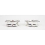 A MATCHED PAIR OF GEORGE IV SILVER WINE COASTERS with gadrooned rims and turned wooden inserts, with