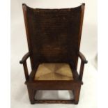 AN EARLY 20TH CENTURY OAK FRAMED ORKNEY CHAIR with rushed back over replacement square rushed seat