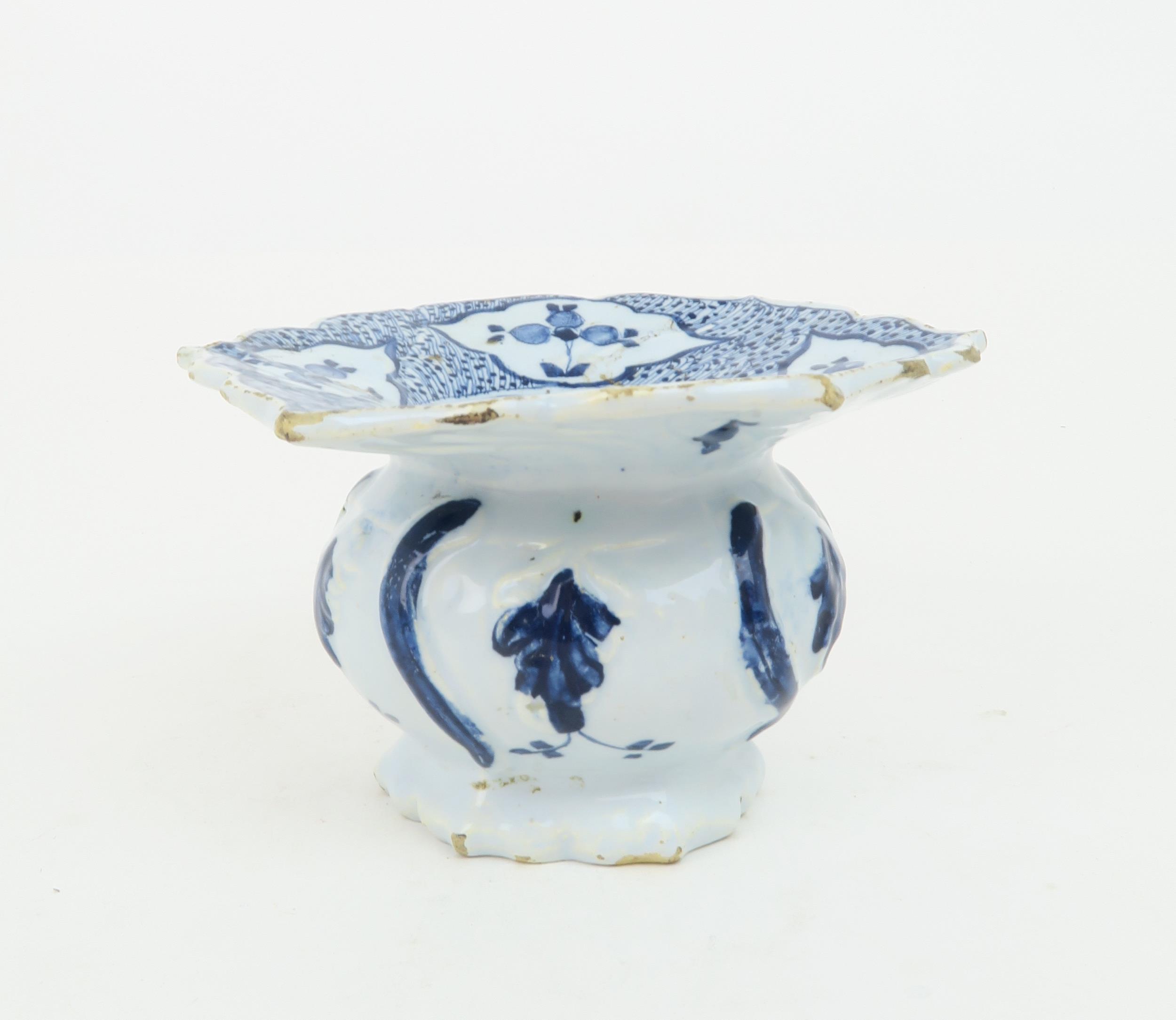 AN 18TH CENTURY DUTCH DELFT SPITTOON with flared scalloped edge, painted with sprigs of flowers,