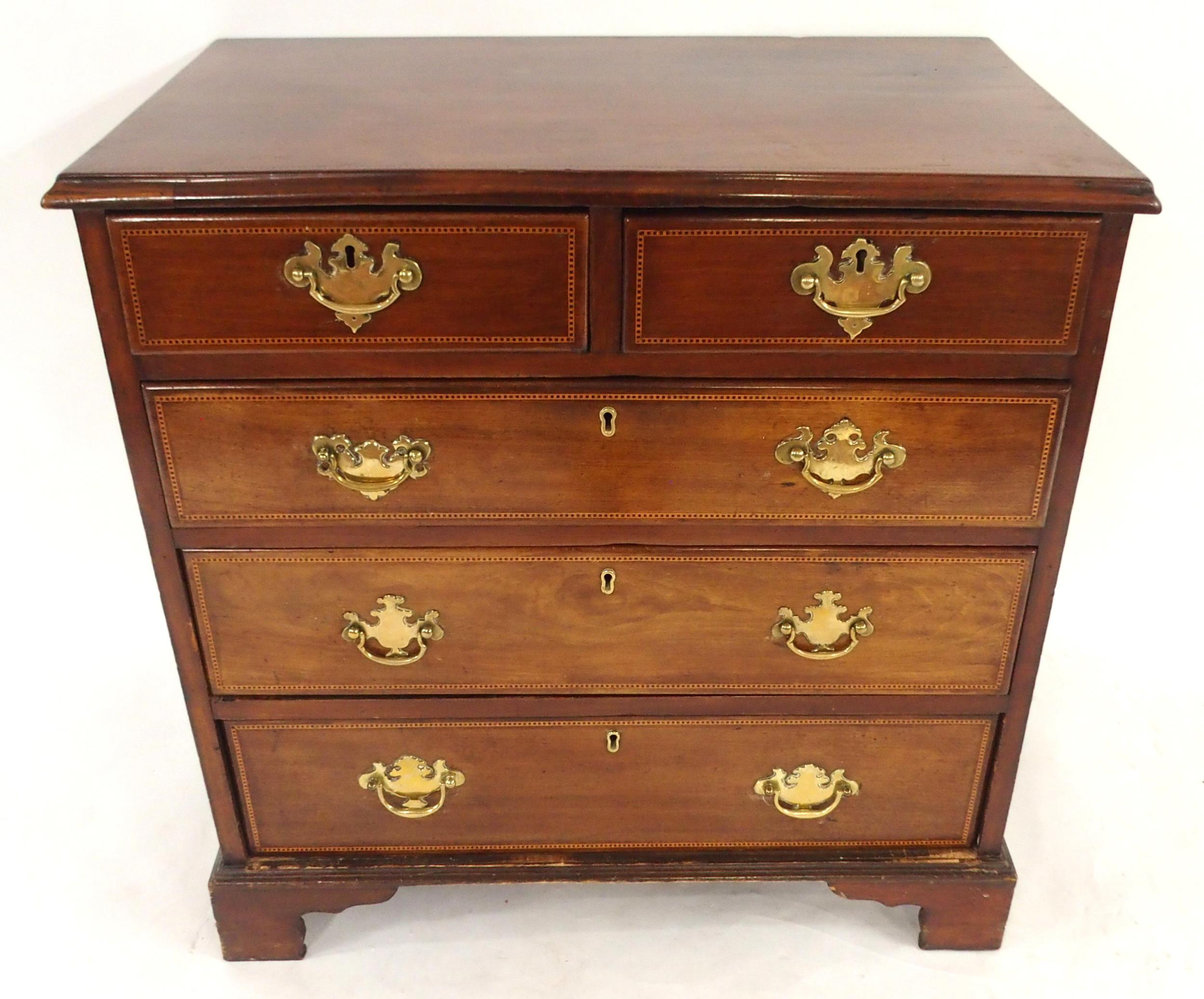 A GEORGIAN MAHOGANY TWO OVER THREE CHEST OF DRAWERS with checker line inlays and brass drawer