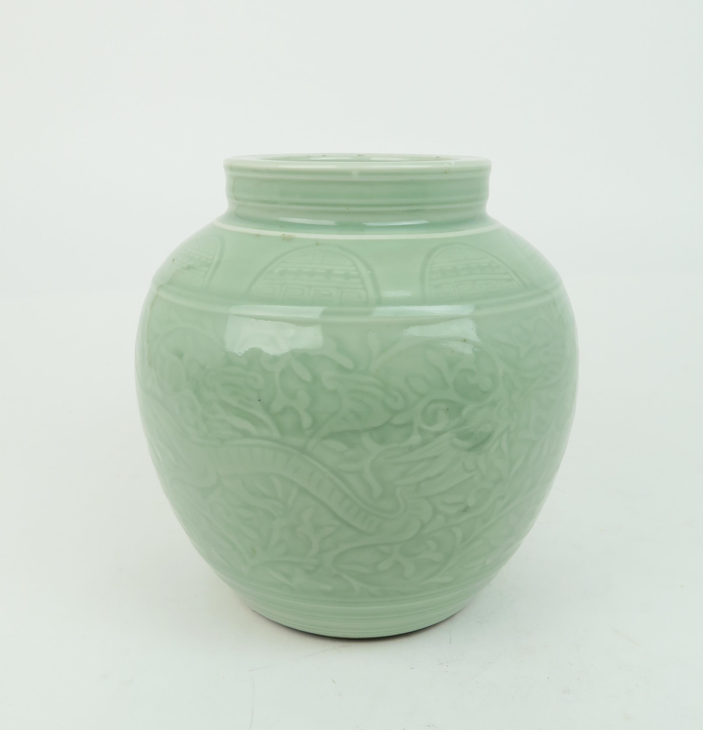 A CHINESE CELADON VASE  Carved with an archaic band above scrolling foliage, and horizontal banding,