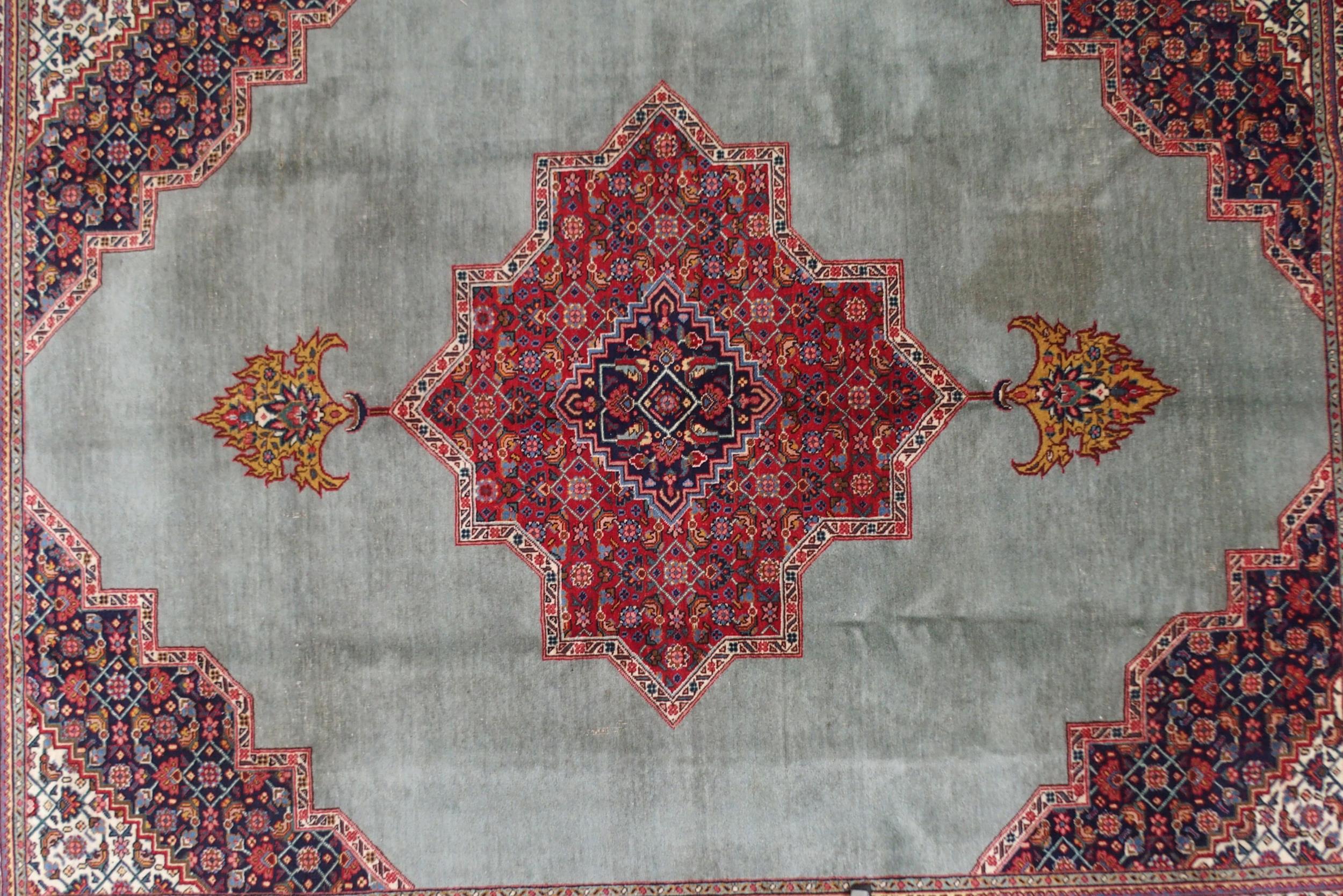A GREEN GROUND TABRIZ RUG with red geometric central medallion, dark blue and white spandrels and - Image 2 of 7