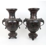 A PAIR OF JAPANESE BRONZE VASES Cast with birds amongst flowering branches, mask handles and on