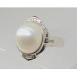 A MABE PEARL & DIAMOND RING set in 14k white gold, the mabe pearl measures 14mm in diameter and is