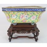 A CANTON ENAMEL YELLOW GROUND JARDINIERE  Painted with peonies and scrolling foliage, beneath a blue