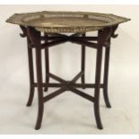 A CHINESE BRASS TOP FOLDING TABLE with octagonal brass tray top over hardwood hexagonal folding