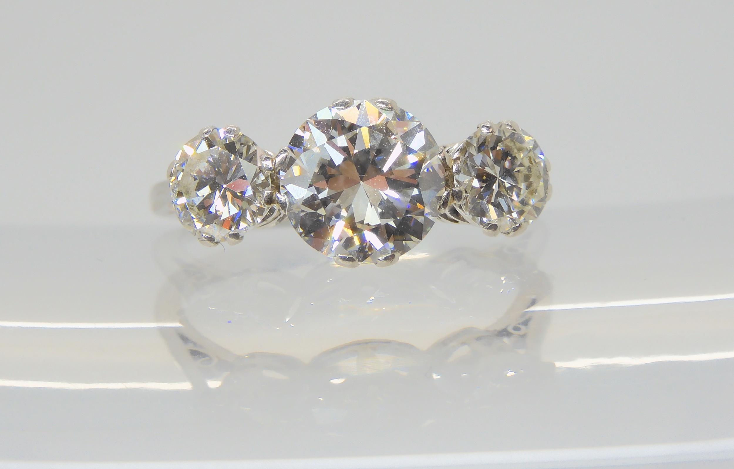 A SUBSTANTIAL DIAMOND THREE STONE RING mounted throughout in platinum, with a really pretty setting.