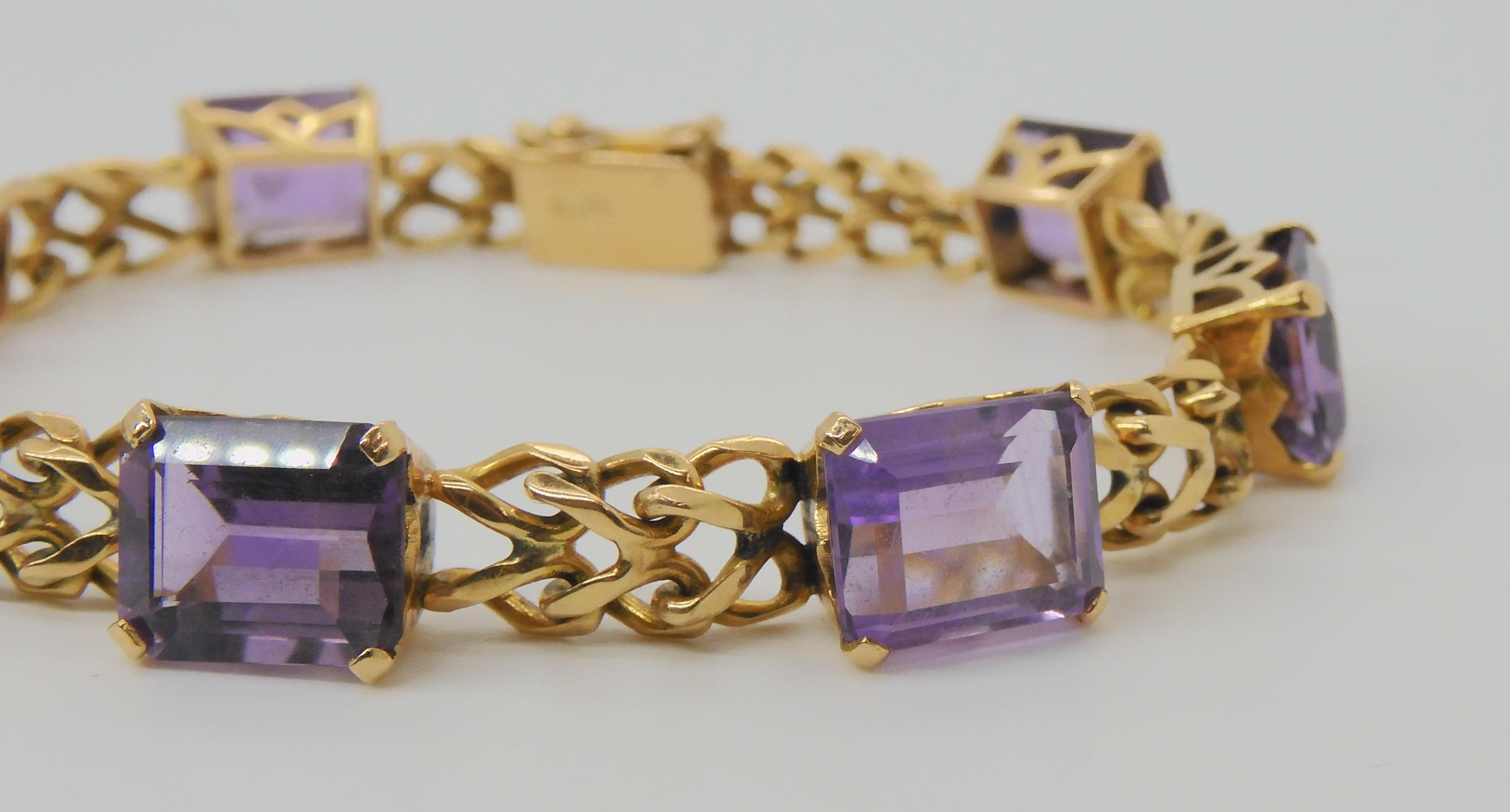 A FANCY LINK AMETHYST BRACELET the box clasp stamped 18k, and set with seven step cut amethysts with