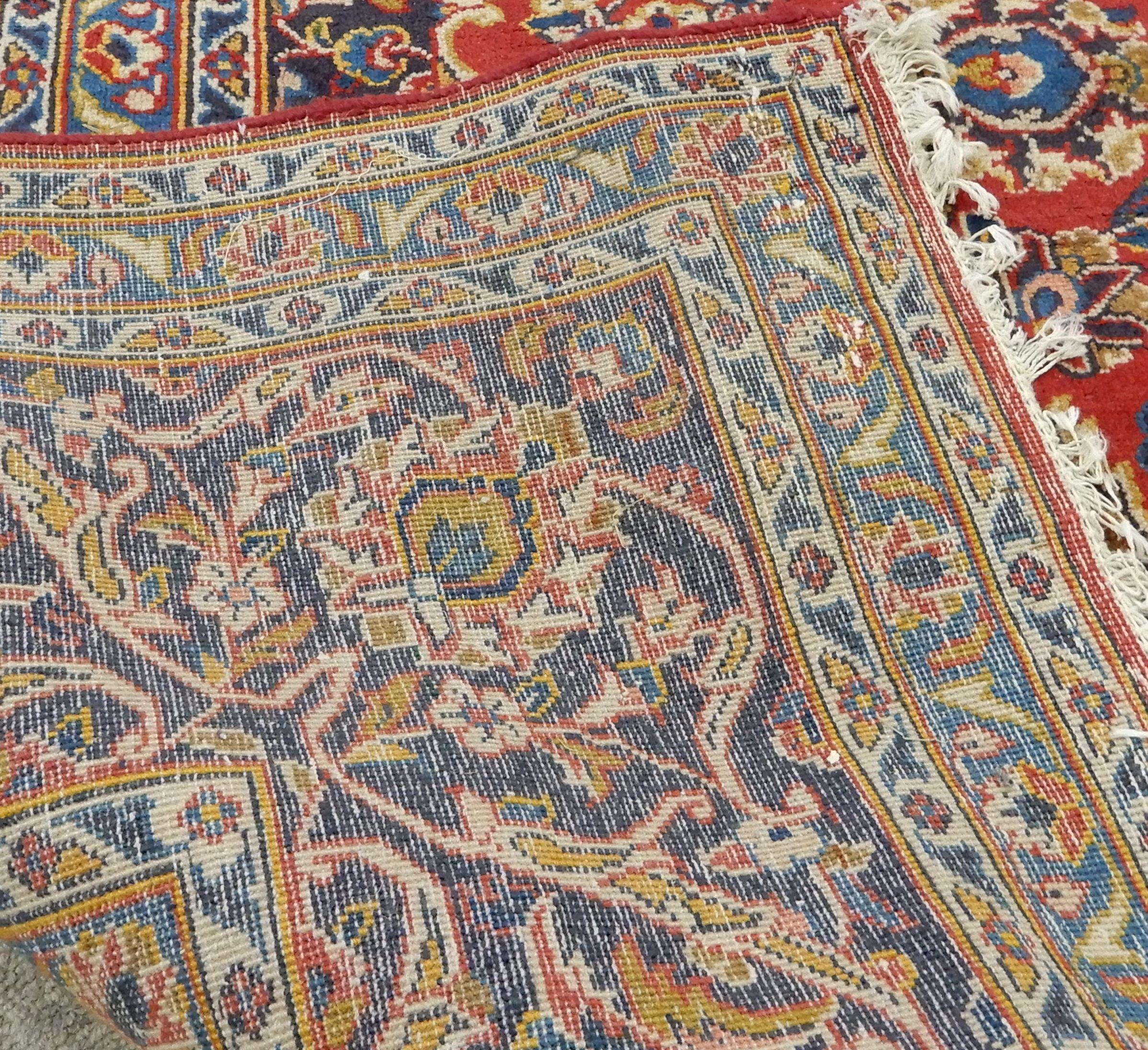 A RED GROUND KESHAN RUG with all over floral foliate design, dark blue central medallion, matching - Image 4 of 5