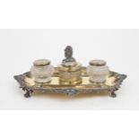A GEORGE IV SILVER GILT INKSTAND of oblong lobed form, with a cast scrolling shellwork border, on