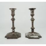 A PAIR OF EDWARDIAN SILVER CANDLESTICKS the faceted knopped stem supported on a further capstan