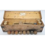 AN EARLY 20TH CENTURY CASED CROQUET SET comprising four mallets (one def), seven balls, three