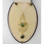 AN EDWARDIAN PENDANT set with two green tourmalines, of approximate diameter 7.3mm, and seed