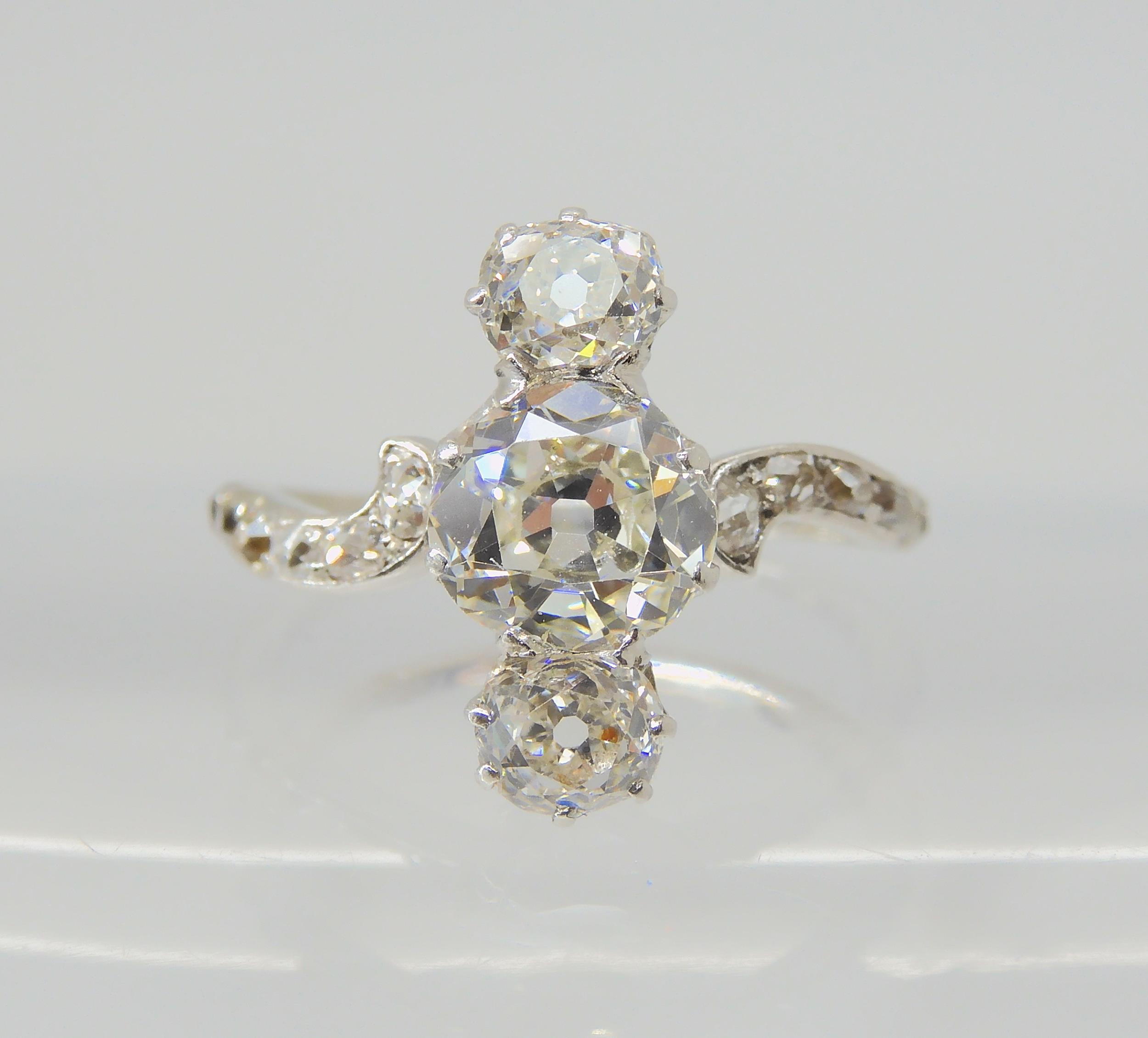 A VINTAGE THREE STONE DIAMOND RING the central old cut is estimated approximately at 0.95cts, with