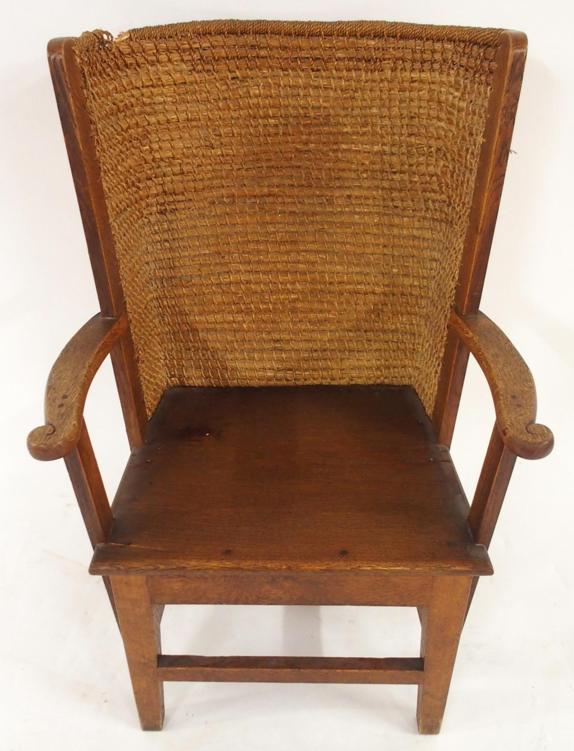 A 19TH CENTURY OAK FRAMED ORKNEY CHAIR with rushed back and shaped arms on stretchered square