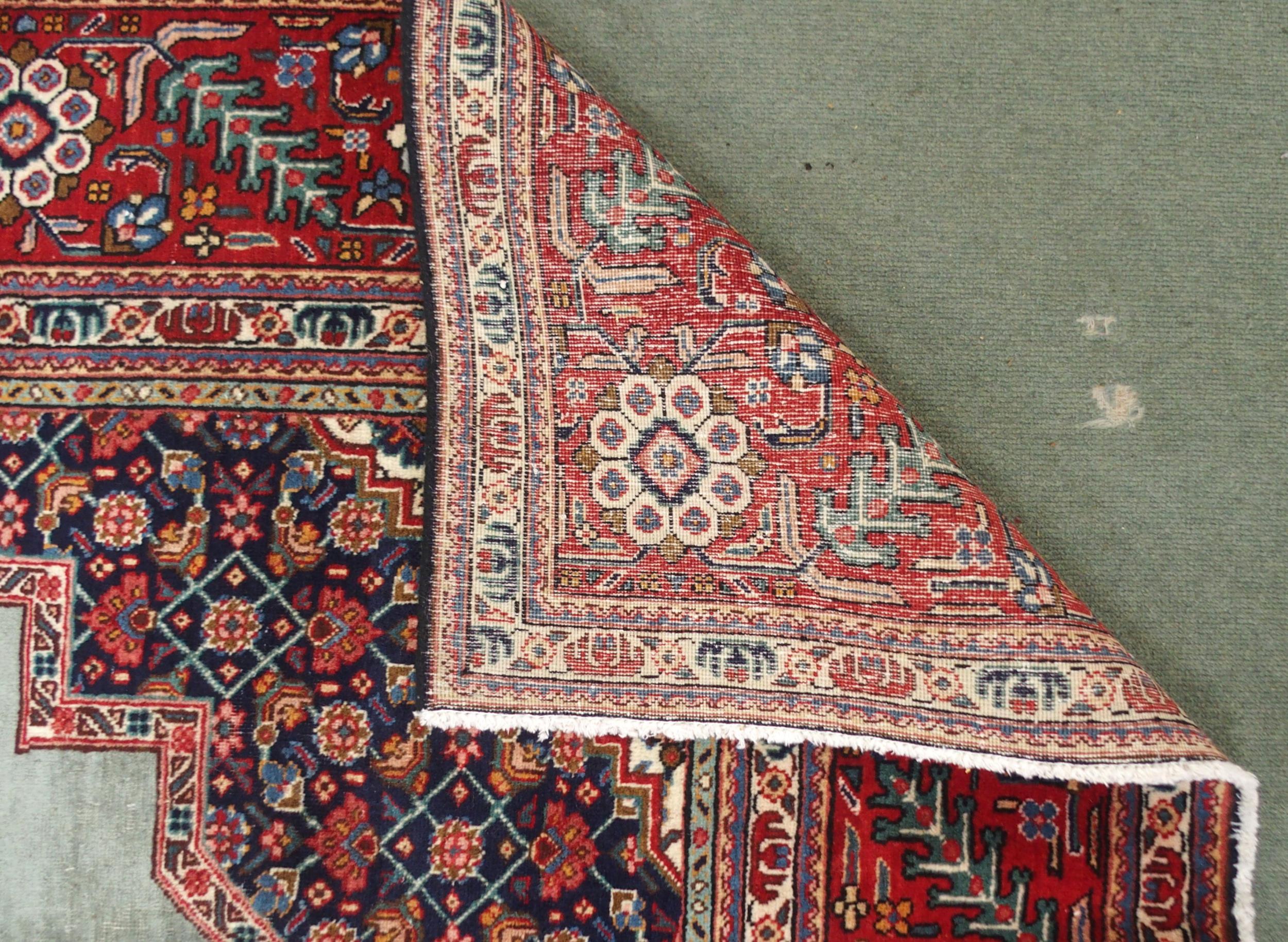 A GREEN GROUND TABRIZ RUG with red geometric central medallion, dark blue and white spandrels and - Image 5 of 7