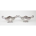 A PAIR OF EDWARDIAN SILVER FRUIT BOWLS of oval form, the bodies with chased and repousse scrolling