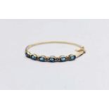 A 9ct gold topaz and diamond hinged bangle