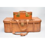 A tan leather suitcase and vanity case