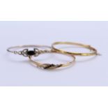 Two 9ct gold bangles and a silver bangle