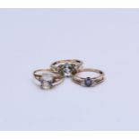 A collection of three stone set rings