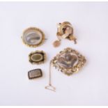 A collection of four mourning brooches and a scroll work brooch