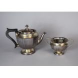 A silver teapot and sugar bowl