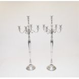 Two pairs of four branch polished steel floor candelabra