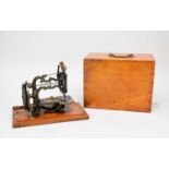A Weir-Raymond sewing machine in wood carrying case
