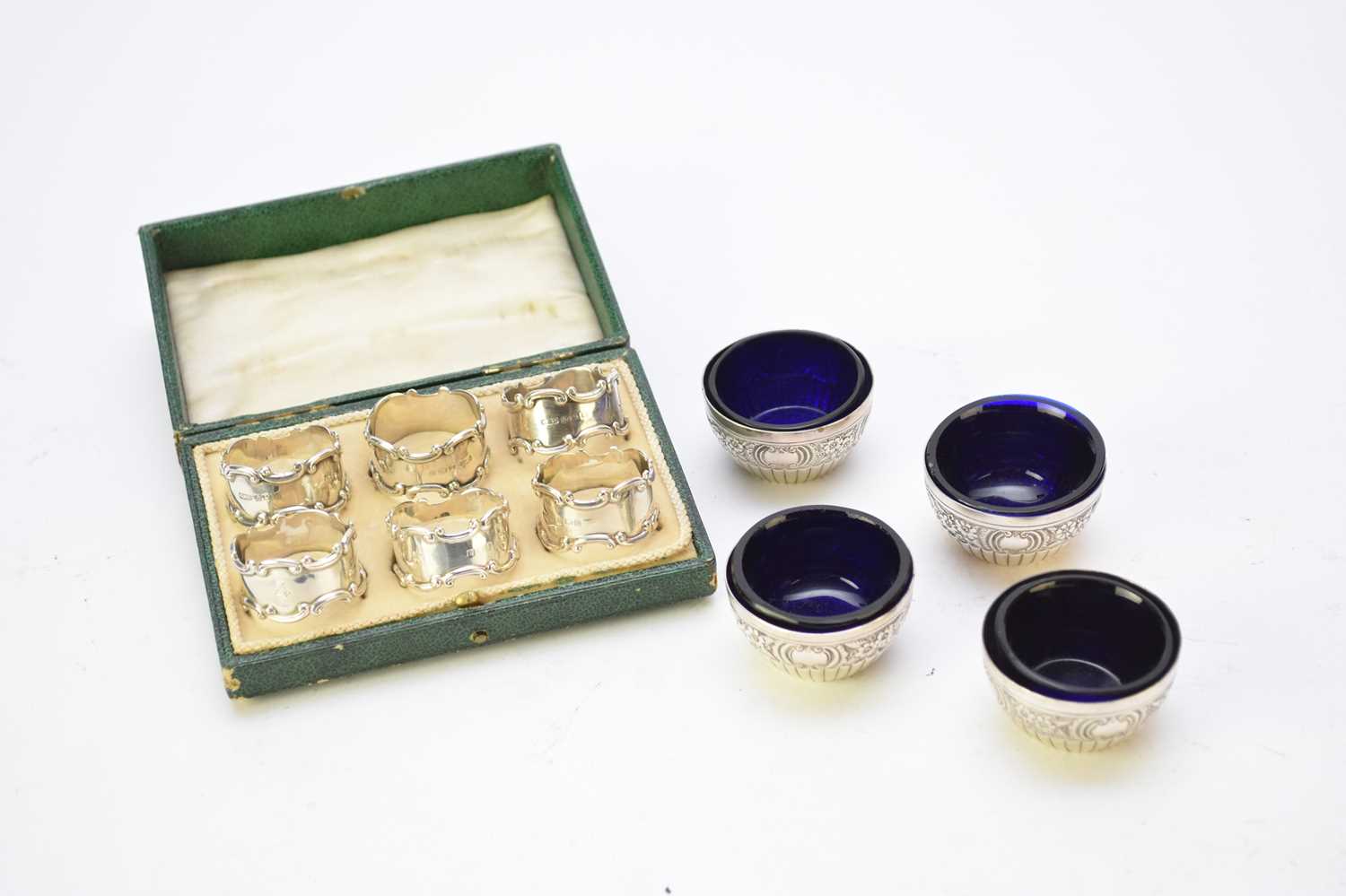 A cased set of silver napkin rings and four silver salts