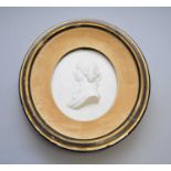 A carved white marble cameo portrait of a young woman