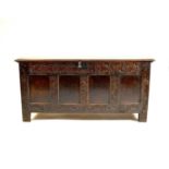 An 18th century four panel carved oak coffer