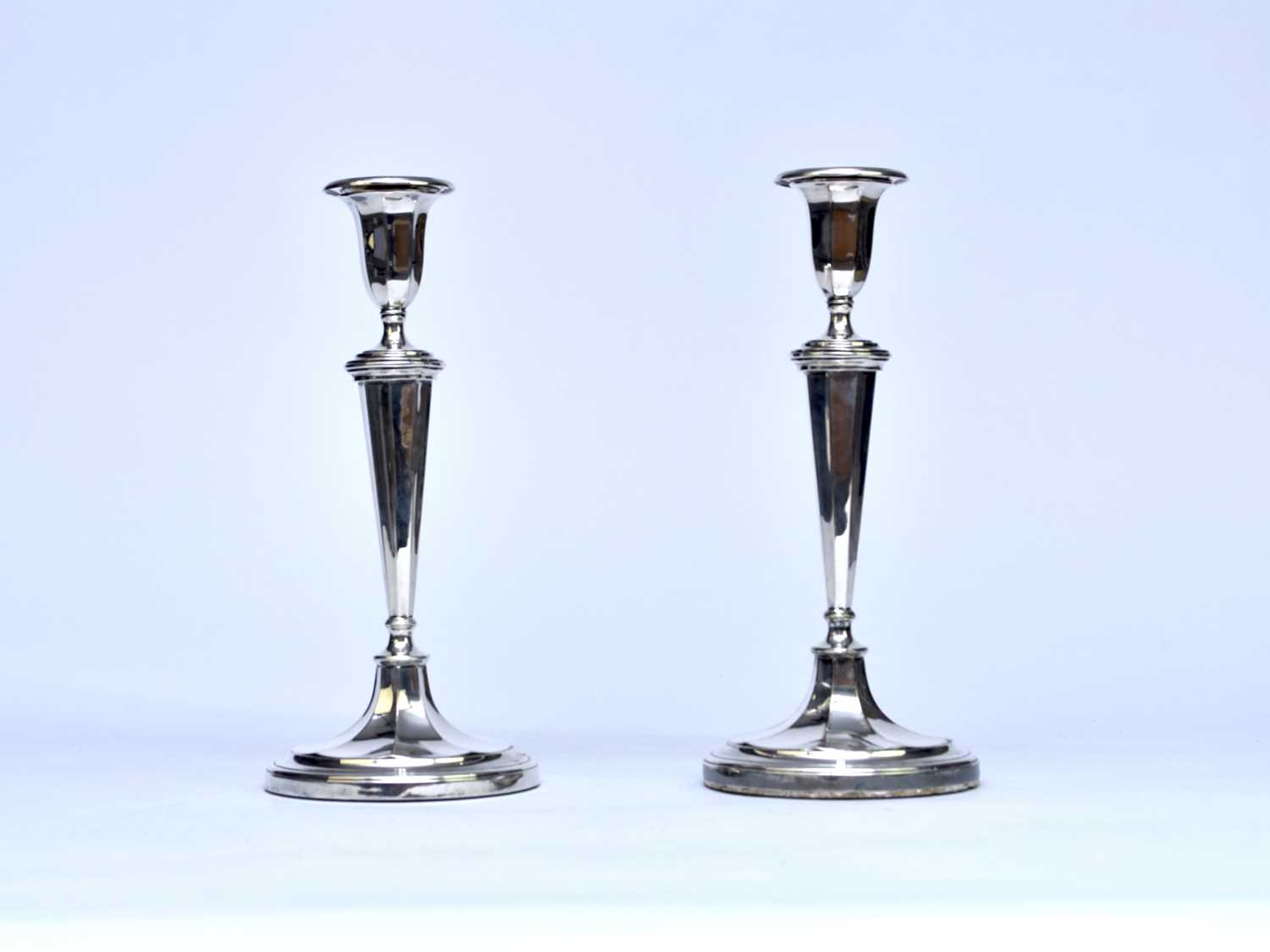 A pair of white metal mounted candlesticks