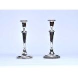 A pair of white metal mounted candlesticks