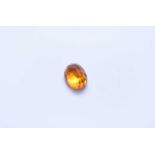 An unmounted oval faceted orange sapphire