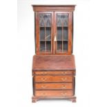 A reproduction parcel ebonised mahogany bureau bookcase