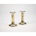 A pair of Edwardian short silver candlesticks