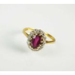 An 18ct gold ruby and diamond oval cluster ring