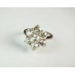 An 18ct white gold seven stone diamond floral cluster ring