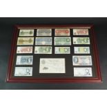 A collection of seventeen United Kingdom banknotes within glazed wood frame