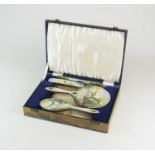 A cased silver and enamel dressing table set