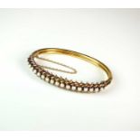 A late 19th century untested pearl hinged bangle