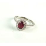 An 18ct white gold oval ruby and diamond cluster ring