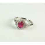 An 18ct white gold oval ruby and diamond cluster ring