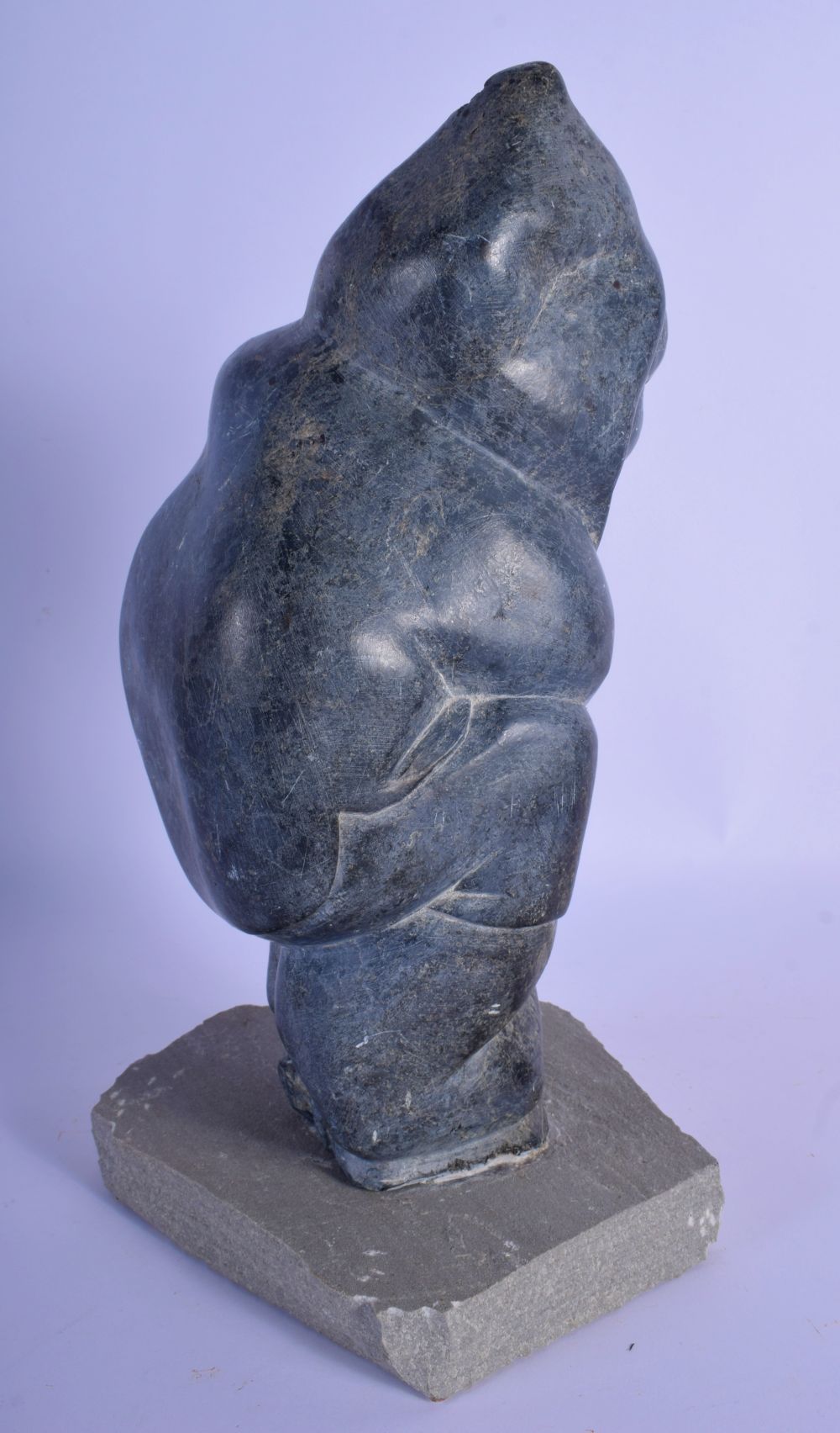 A LARGE NATIVE AMERICAN CANADIAN INUIT CARVED STONE FIGURE modelled holding a fish upon a stone base - Image 3 of 4