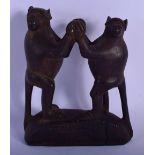 AN UNUSUAL TRIBAL CARVED WOOD FIGURE OF DANCING BABOONS modelled upon a shaped base. 18 cm x 11 cm.