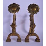 A PAIR OF ARTS AND CRAFTS BRASS FIRE SIDE DOGS modelled with large flower motifs. 34 cm x 16 cm.