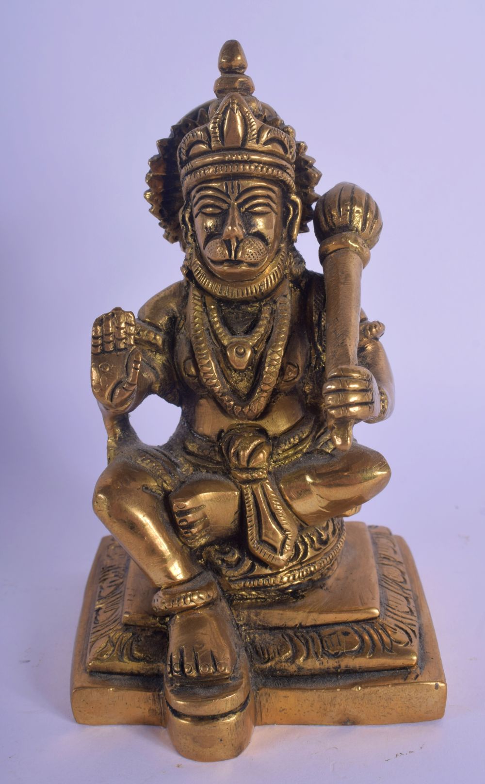 AN INDIAN BRONZE FIGURE OF A SEATED TIGER GOD modelled holding a sceptre. 12 cm x 6 cm.