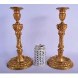 A PAIR OF 19TH CENTURY FRENCH GILT BRONZE CANDLESTICKS decorated with rams head mask heads. 33 cm hi